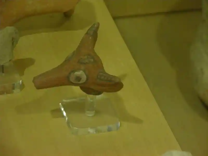 Bull head with a cross on its forehead and squares on its horns made out of clay